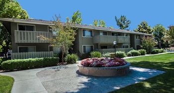 Apartment complex with a flower bed in front at Cherrywood Apartments, San Jose, 95118